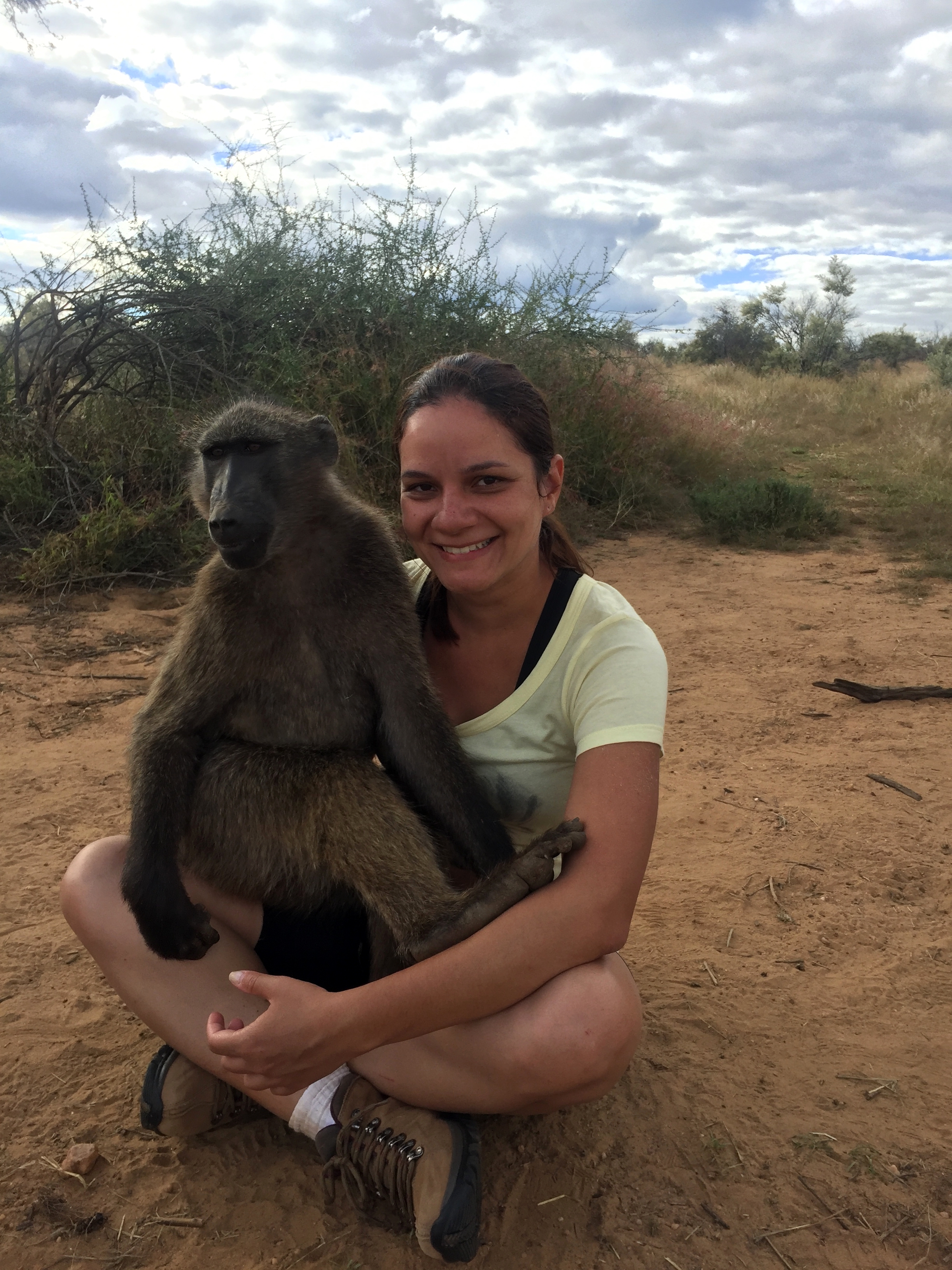 Vivian segurando um babuíno no colo. Trabalho voluntário na Namíbia